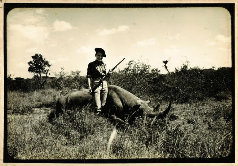 Virginia Kraft poses with a rhino in the Kenyan lanscape.