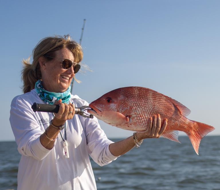 Connie O&rsquo;Day holds up a large redfish off the coast of southeast Louisiana the day before the 2023 Louisiana SLAM Tournament begins on June 4, 2023.