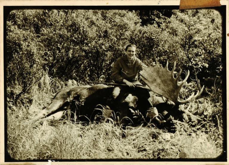 Virgina Kraft poses with a fallen moose, 1959.